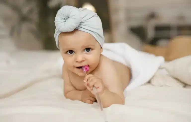 Bebeluș cu periuță de dinți - igienă dentară de la primul dinte de lapte